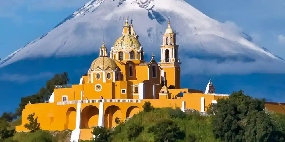 Church of Nuestra Señora de los Remedios in Cholula with Popocatepetl behind it