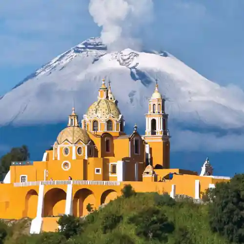 Church of Nuestra Señora de los Remedios in Cholula with Popocatepetl behind it
