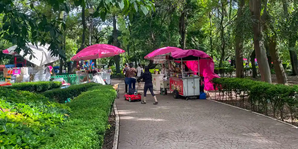 Vendors, families, and shaded paths in Parque México in Condesa