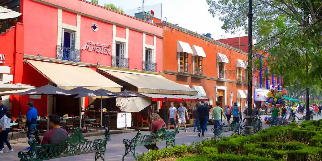 People walking past cafés along Avenida Francisco I. Madero in Coyoacán