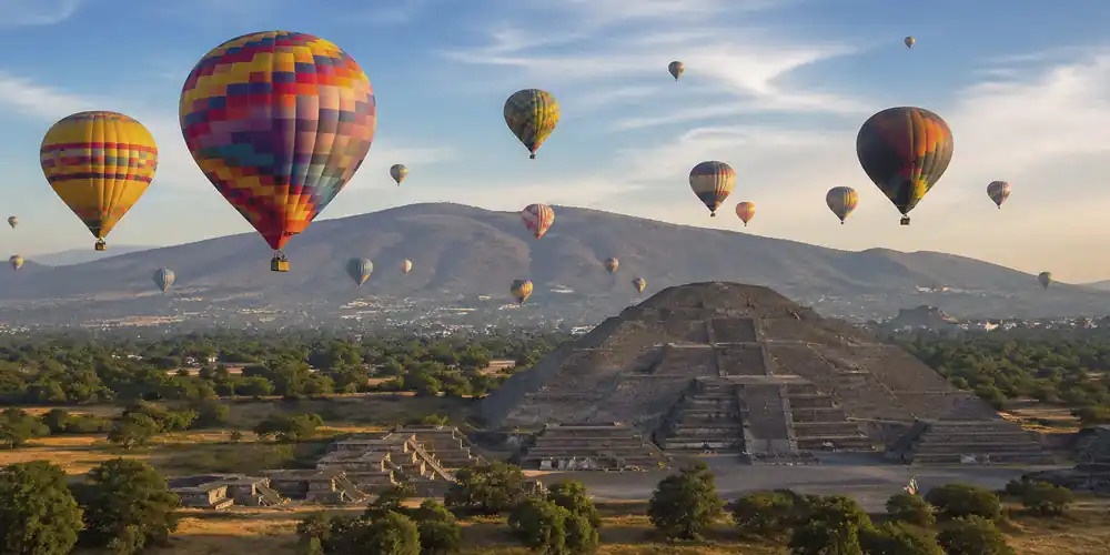 Hot air balloons over the pyramids of Teotihuacán at sunrise
