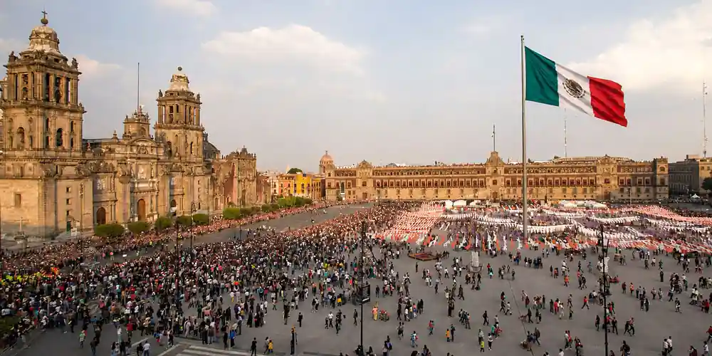 The Zócalo in Mexico City with the Metropolitan Cathedral, National Palace, and giant Mexican flag.